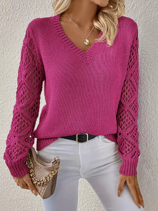 Person wearing a pink sweater with mesh sleeves against a neutral background
