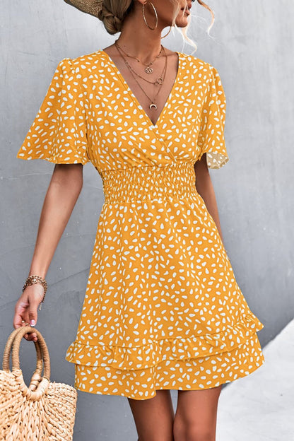 Woman wearing a yellow polka dot dress against a gray background