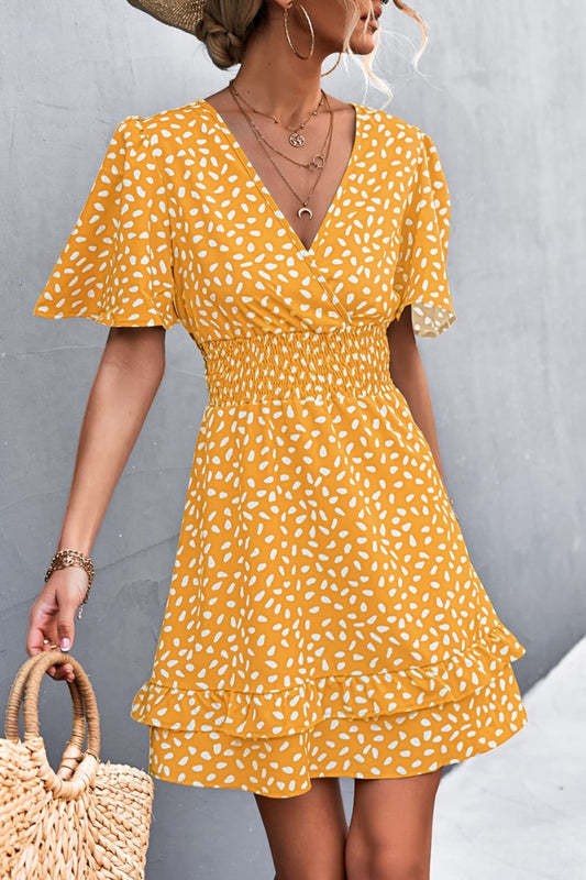 Woman wearing a yellow polka dot dress against a gray background
