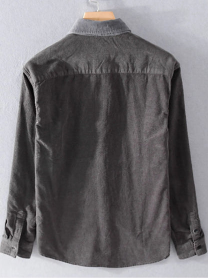 Dark gray denim jacket on a hanger against a light gray background
