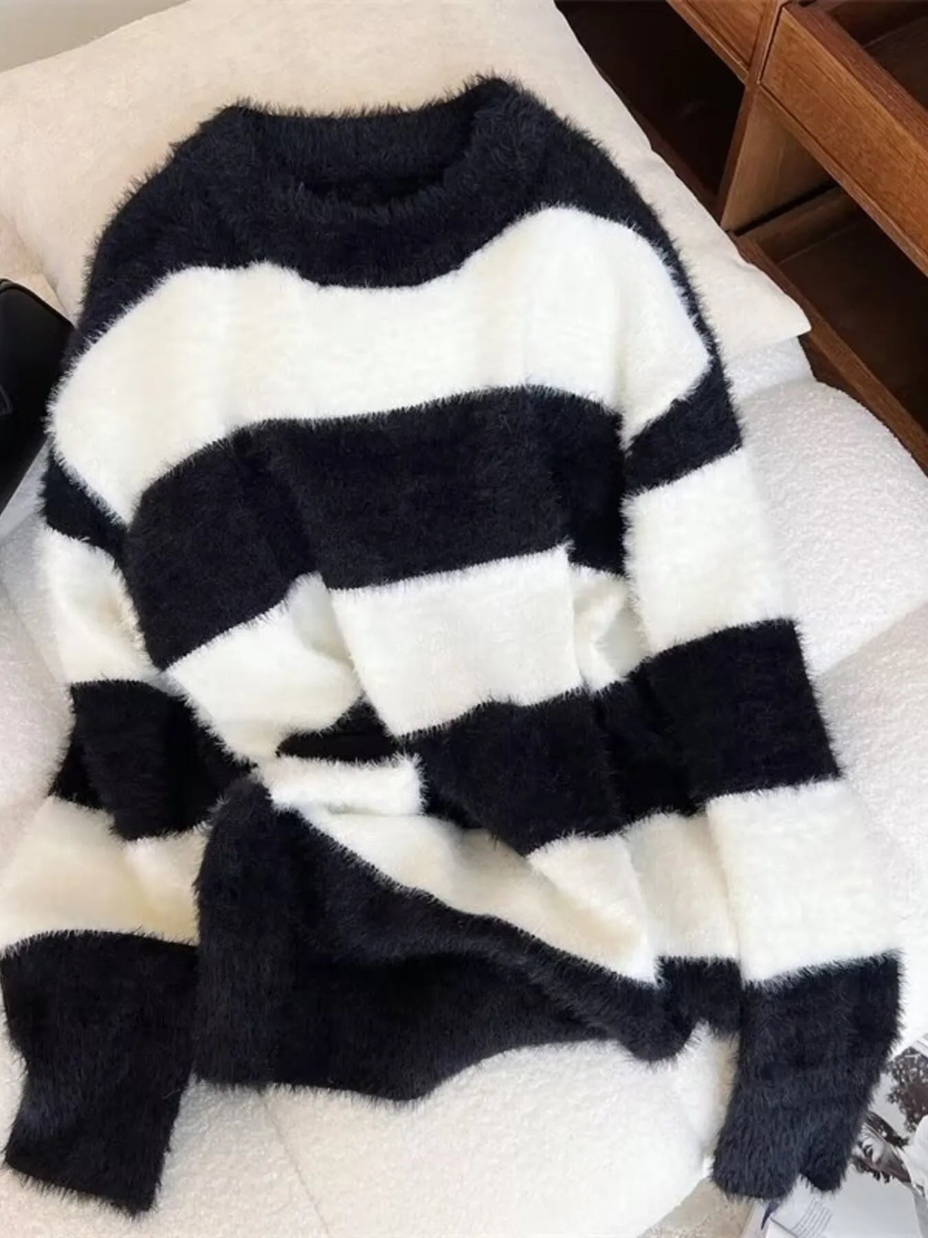 Black and white striped sweater on a bed