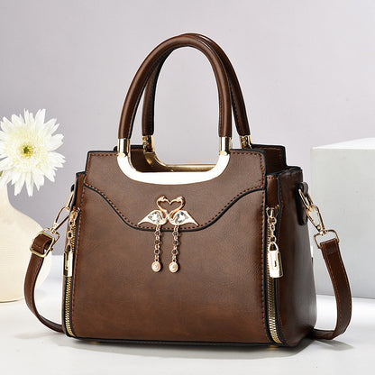 Handbag with gold accents with a single flower and white background.