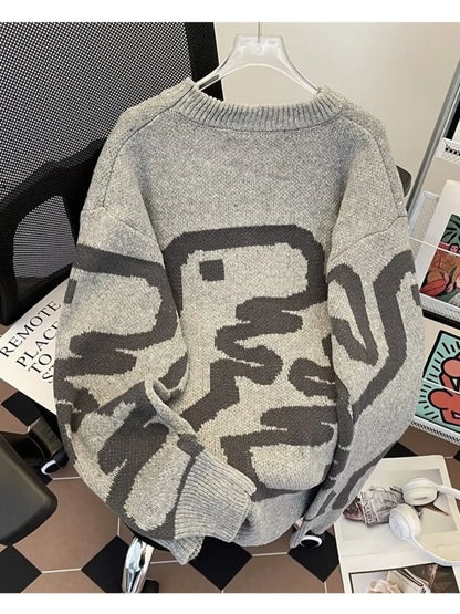 Gray sweater with black abstract patterns on a chair