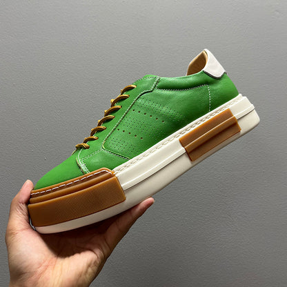 Green sneaker with brown accents held against a gray background