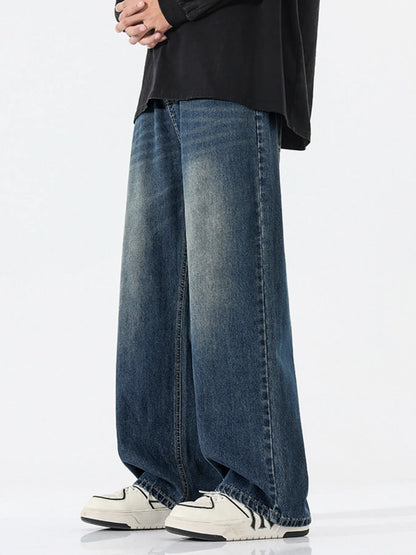 Person wearing wide-leg jeans and white sneakers on a white background