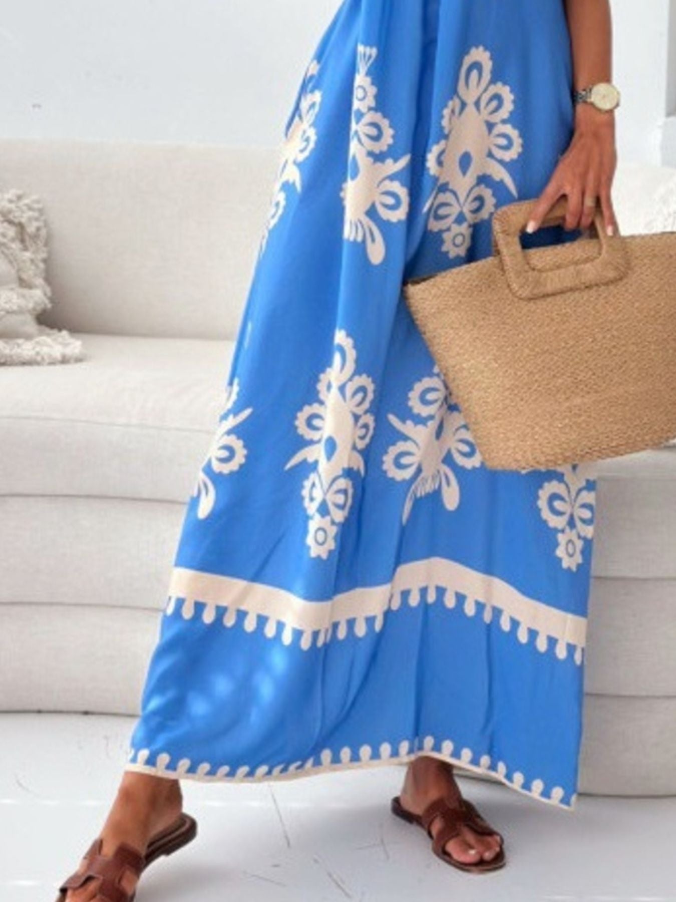 Person holding a blue patterned towel with a beige border indoors.