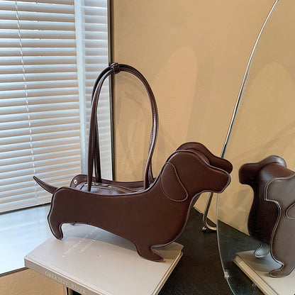 Brown dog-shaped handbag on a surface with a mirror reflection.