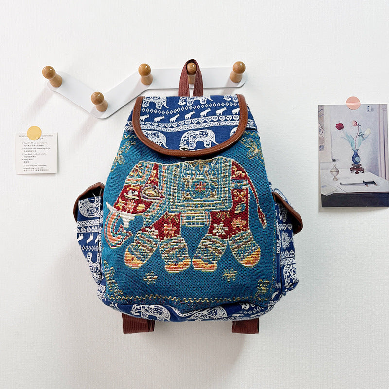 Decorative backpack with elephant design on a white wall