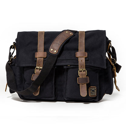 Black canvas bag with brown leather straps on a white background