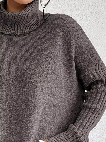 Close-up of a person wearing a gray turtleneck sweater against a white background