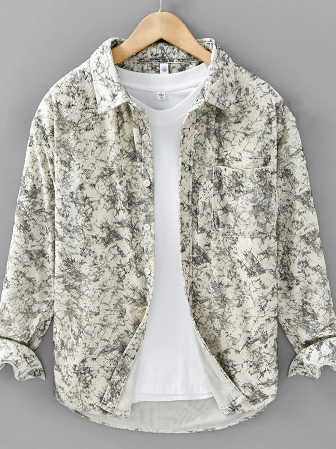 Floral patterned shirt over a white t-shirt on a gray background
