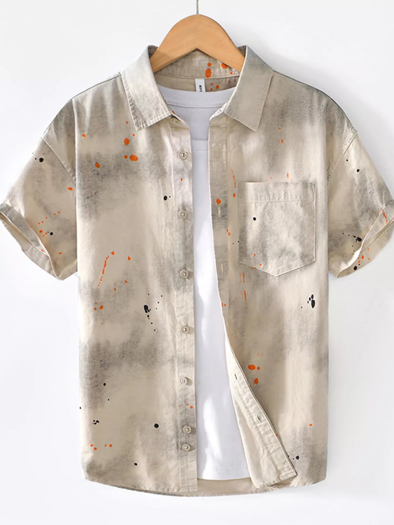 Short-sleeve shirt with abstract pattern on a hanger against a white background