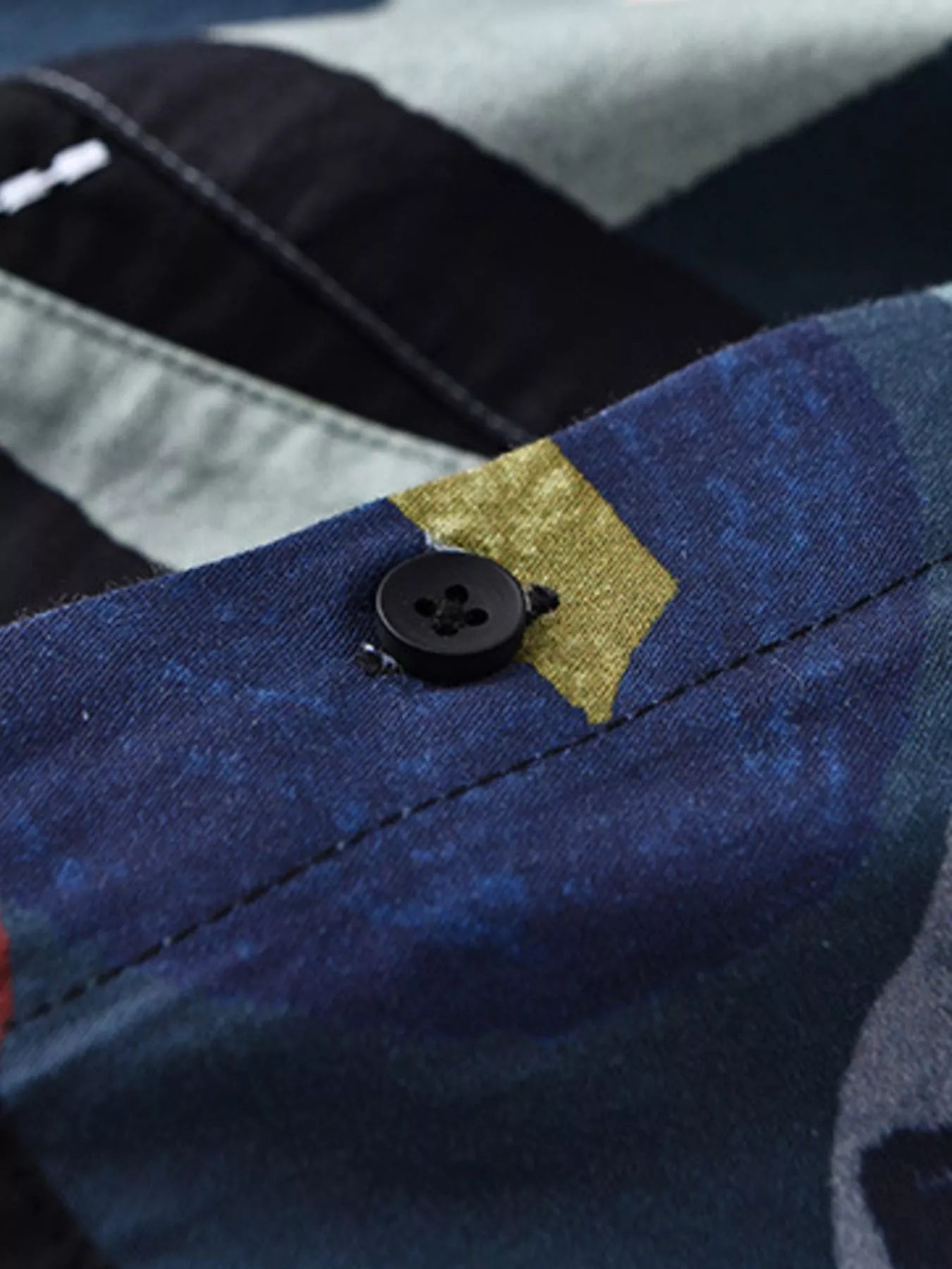 Close-up of a button on a shirt with a geometric pattern in the background