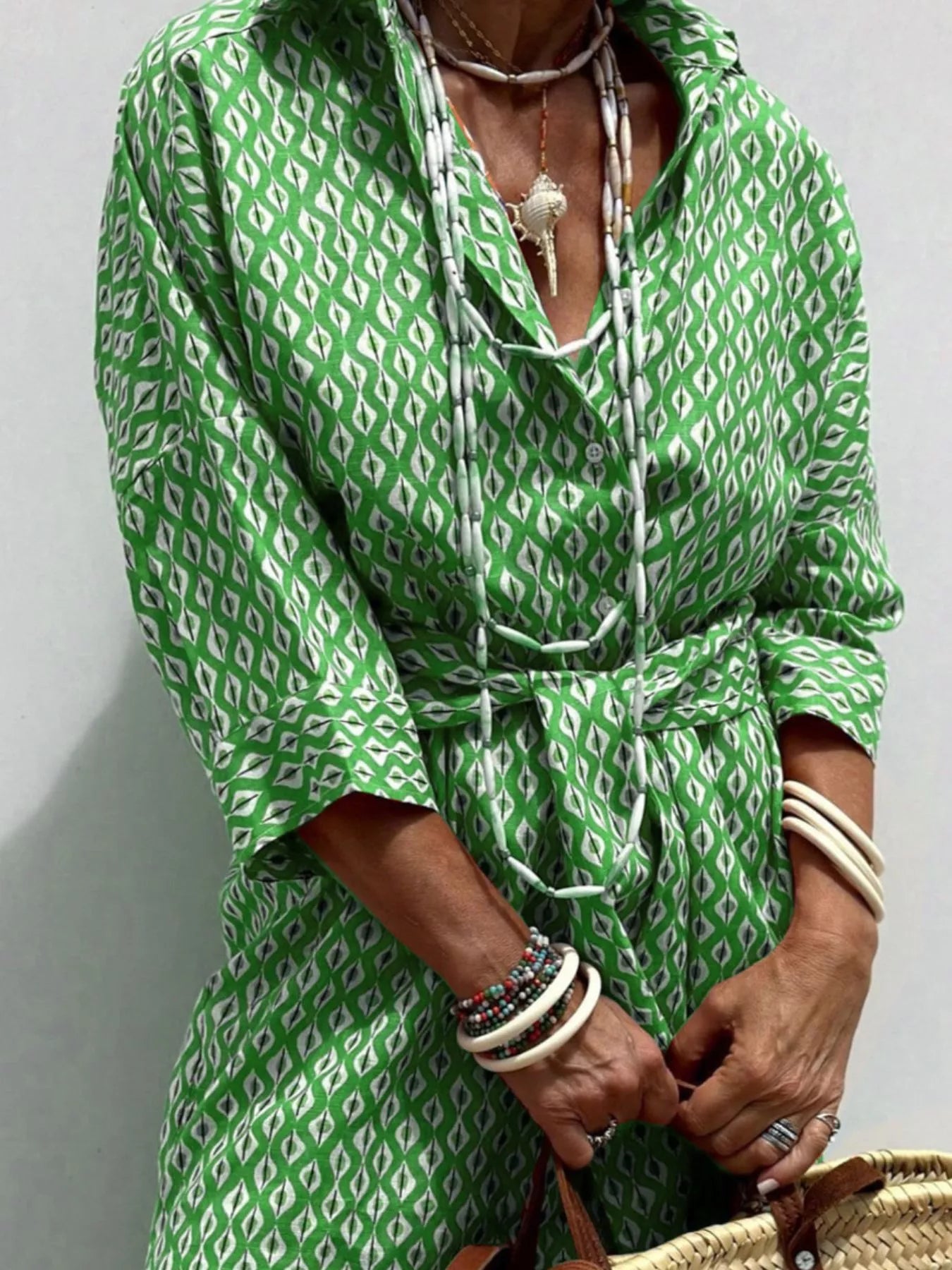 Person wearing a green patterned outfit with a plain background