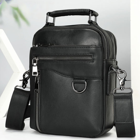 Black leather crossbody bag with multiple zippers on a light gray background