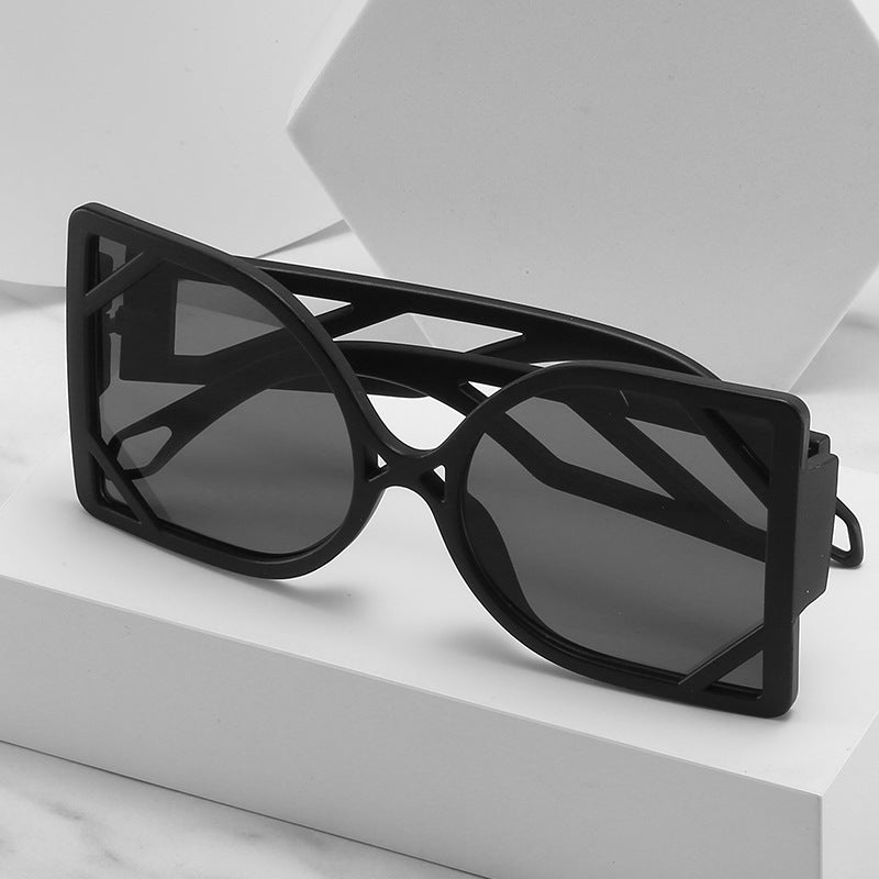 Black sunglasses with geometric frame on a white surface