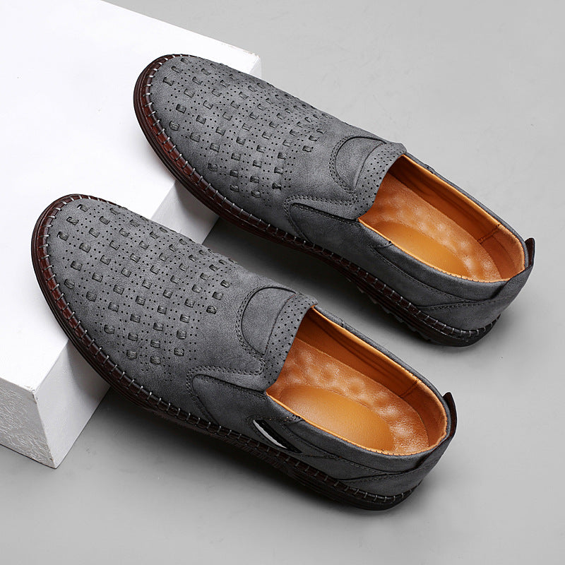 Pair of gray loafers with brown soles on a light gray background