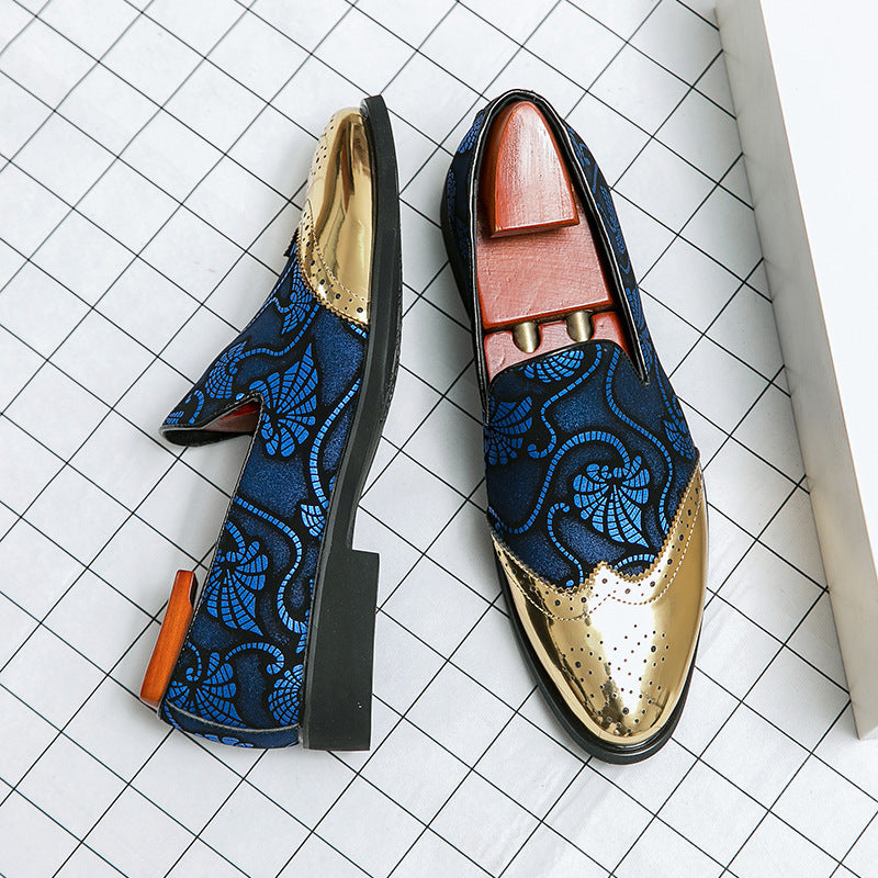 Pair of loafers with blue floral pattern and gold accents on a grid background