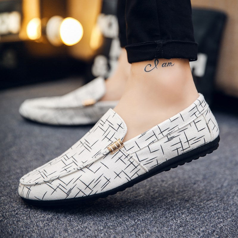 White loafers with black pattern worn by a person on a blurred background