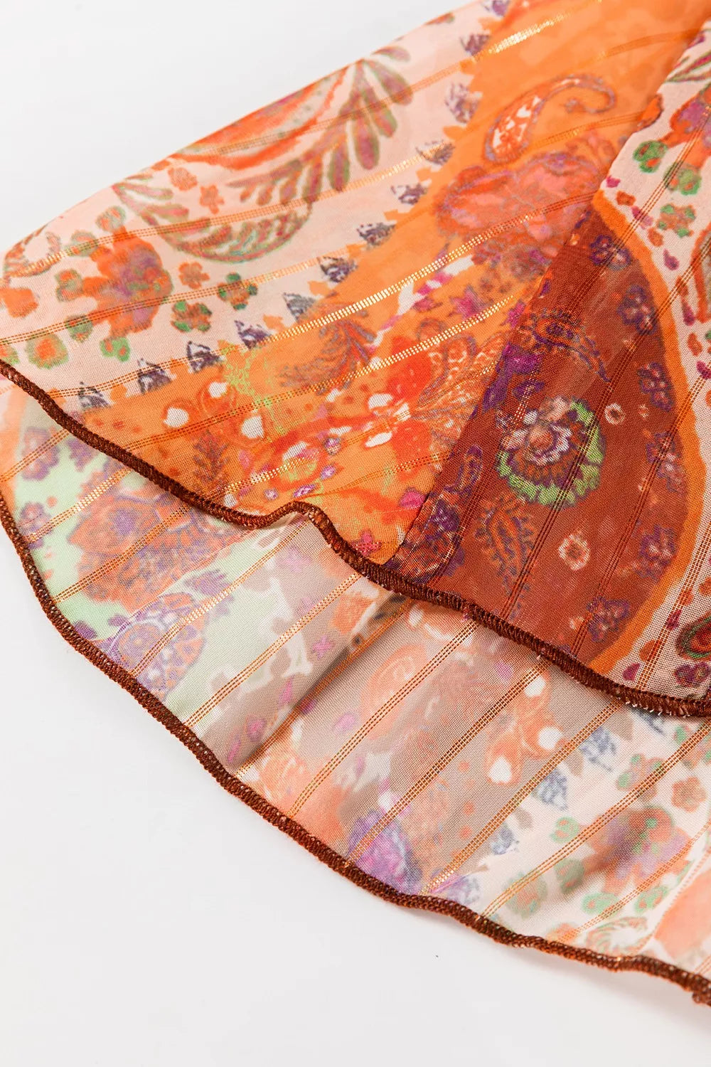 Colorful patterned fabric with orange and pink tones on a white background