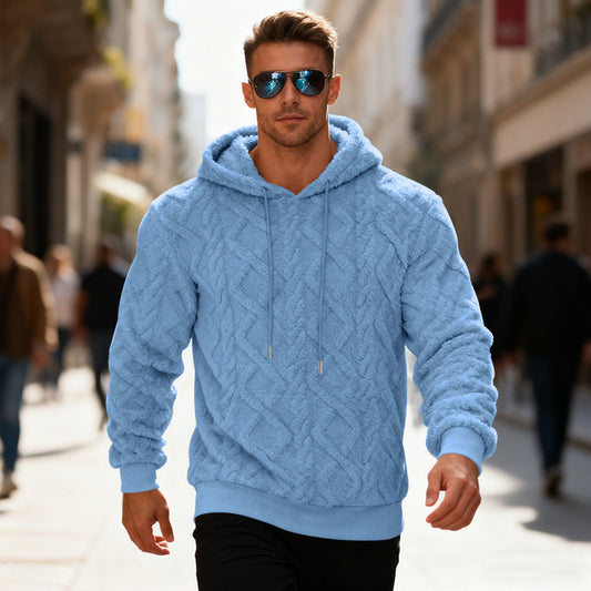 Man wearing a blue cable knit hoodie and sunglasses on a city street.
