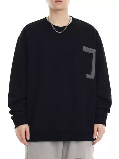 Person wearing a black sweatshirt with a geometric design on a white background