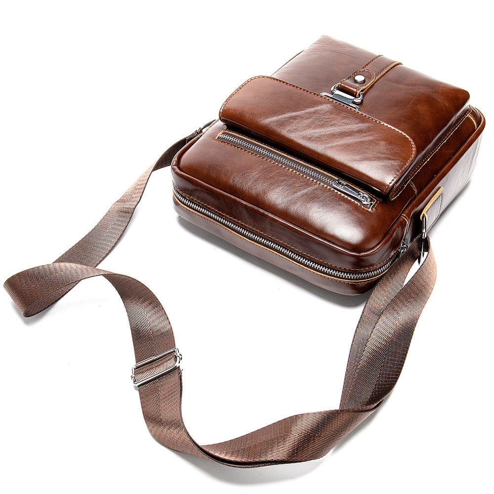 Brown leather crossbody bag with a strap on a white background
