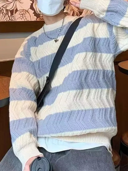 Person wearing a striped sweater with a black strap over their shoulder.