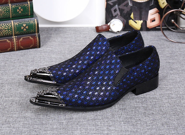 Blue patterned loafers on a gray surface with books and a watch in the background