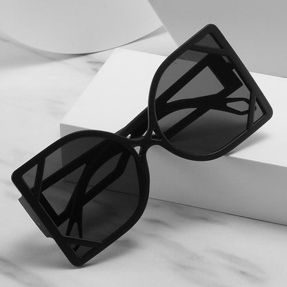 Black sunglasses on a white surface with a gray background