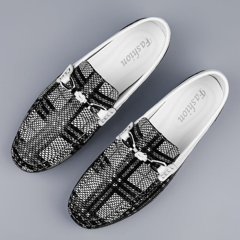 Black pattern slip-on shoes with decorative buckles on a gray background