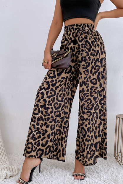 Person wearing leopard print pants with a plain background