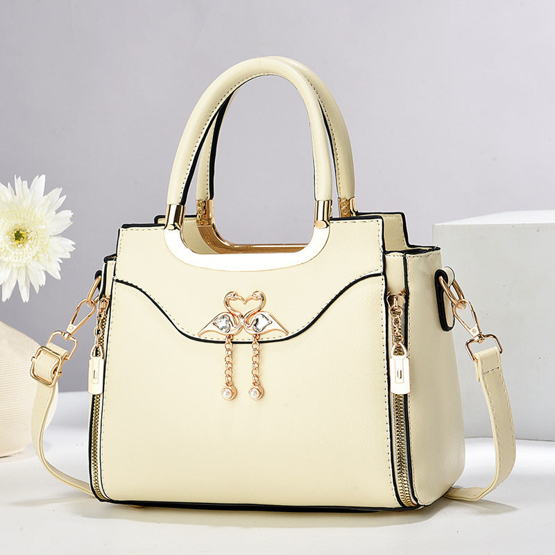 Handbag with gold accents with a single flower and white background.