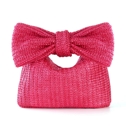 Pink handbag with a large bow on a white background