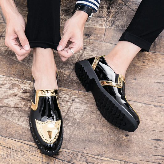Black shoes with gold accents on a wooden floor