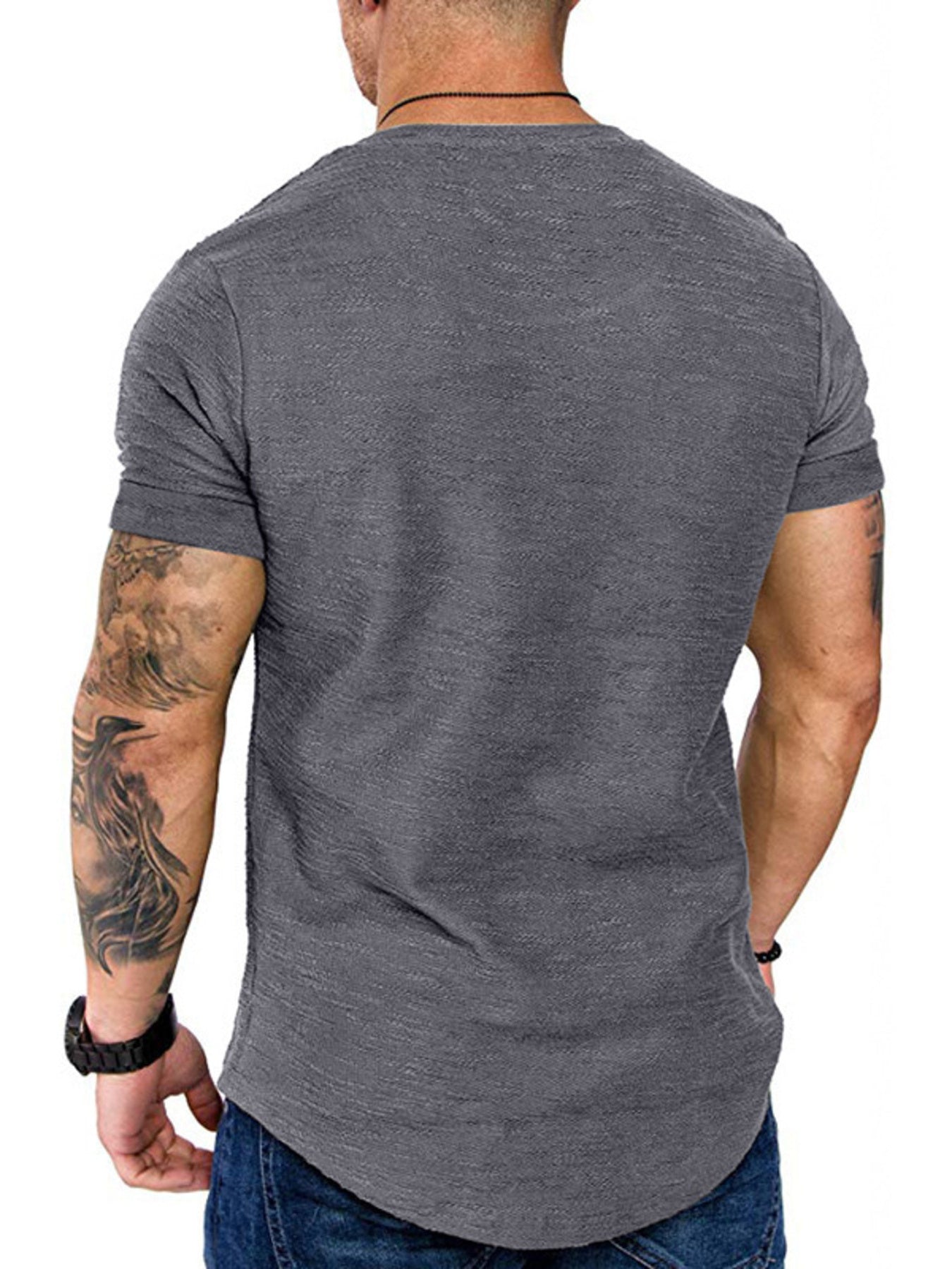 Man wearing a gray t-shirt with visible tattoos on arms, on a white background