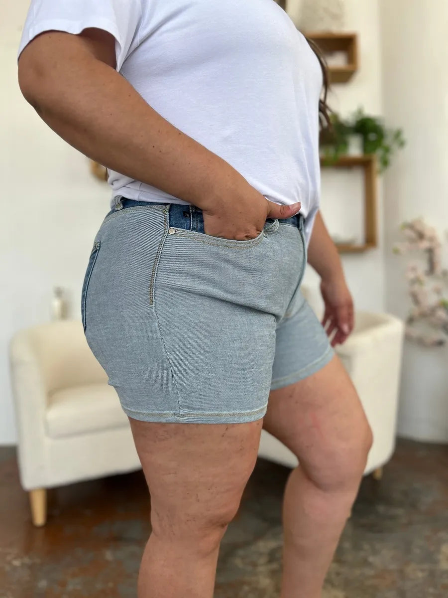 Person wearing light blue denim shorts in a casual indoor setting