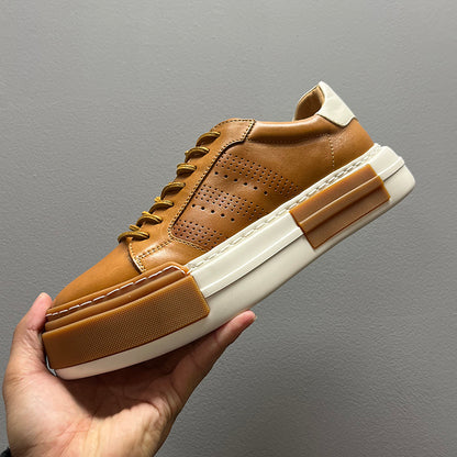 Brown leather sneaker with white sole held against a gray background