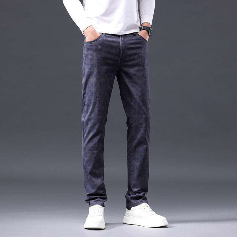 Person wearing dark gray pants and white shoes on a gray background