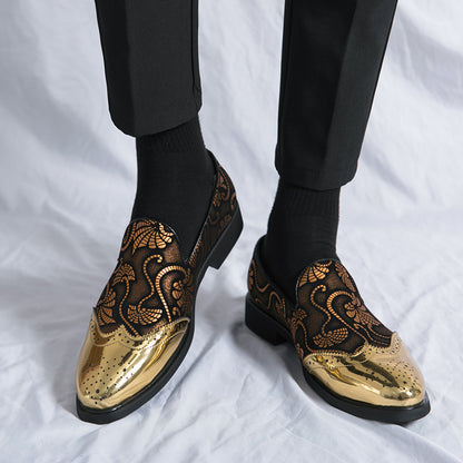 Gold and black patterned shoes worn with black pants on a white background