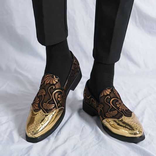 Gold and black patterned shoes worn with black pants on a white background