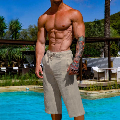 Man with tattoos standing by a pool with a scenic background