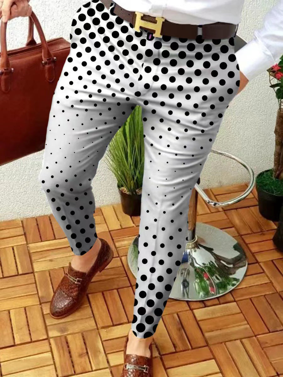 Person wearing polka dot pants with a brown belt, standing on a wooden floor.