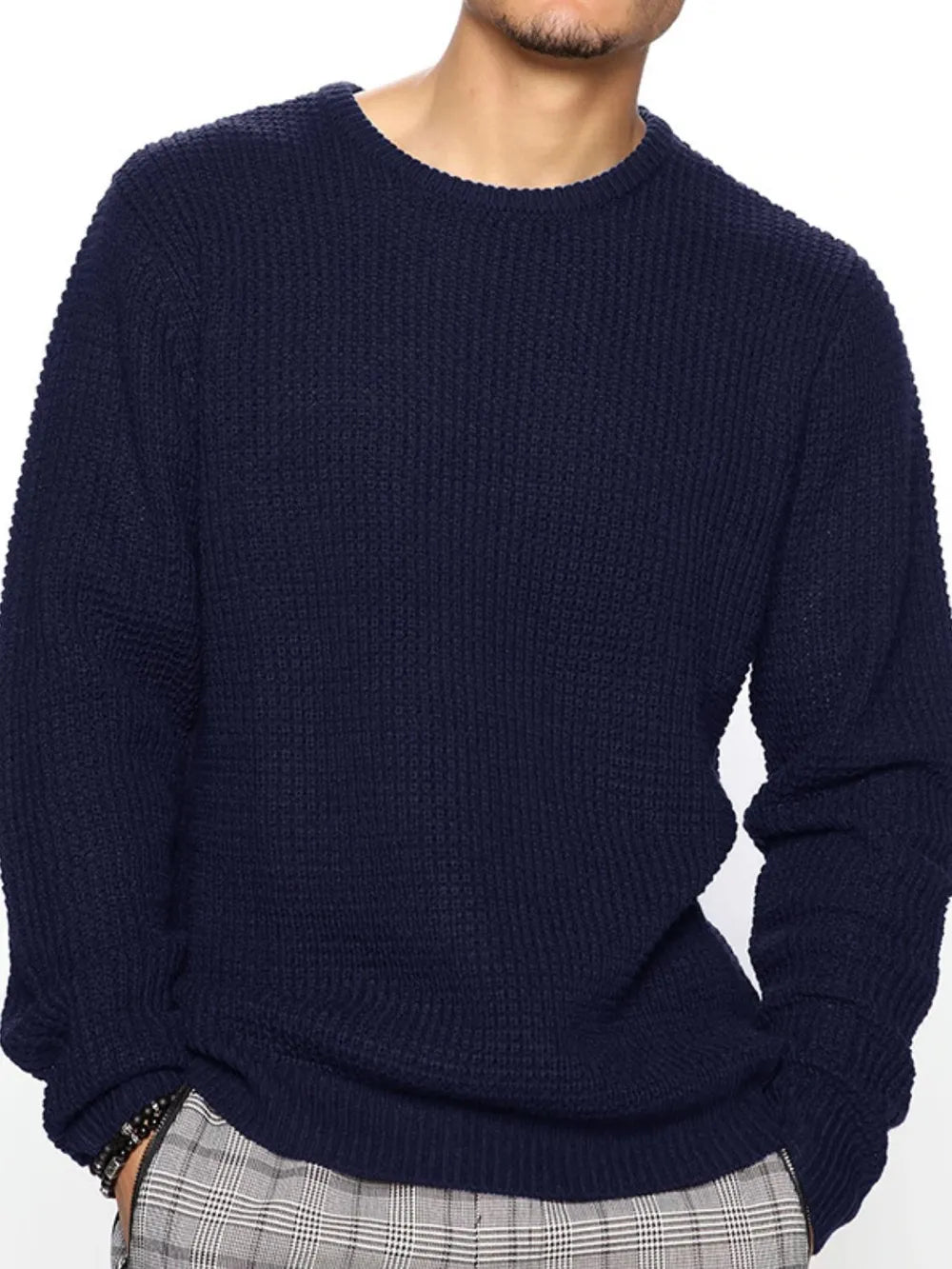 Person wearing a navy blue sweater on a white background