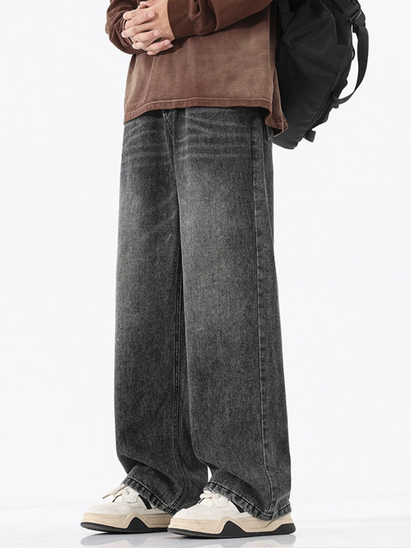 Person wearing wide-leg jeans with a plain background