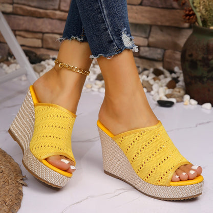 Yellow wedge sandals worn with denim jeans on a light background