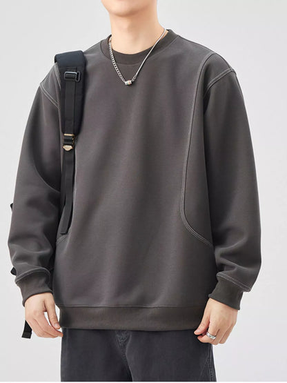 Person wearing a dark gray sweatshirt with a plain background