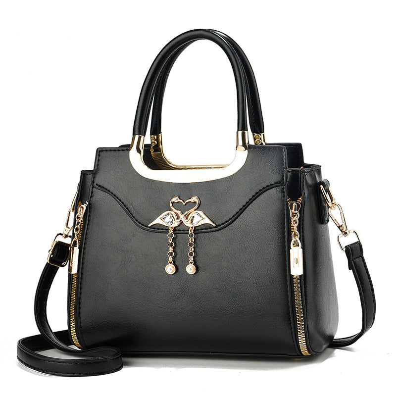 Handbag with gold accents with a single flower and white background.