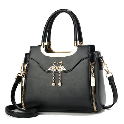 Handbag with gold accents with a single flower and white background.