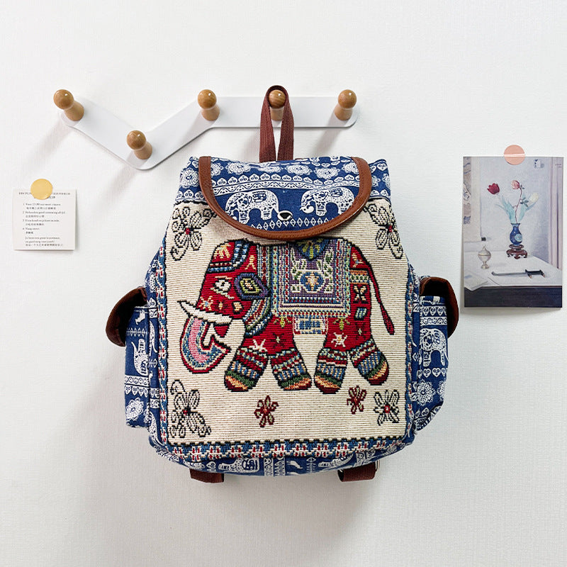 Backpack with elephant design hanging on a wall hook
